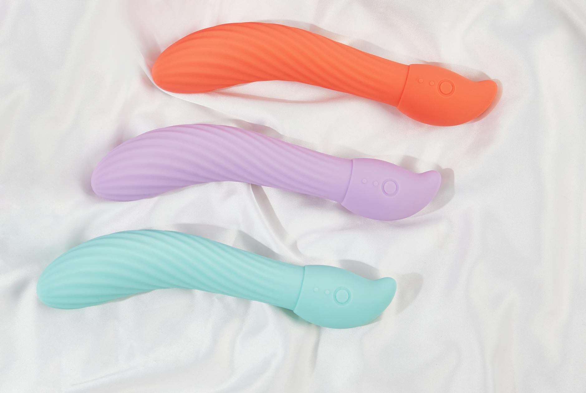 Vibromasseurs colorés avec fleurs dans un sac cadeau holographique sur fond jaune vif
