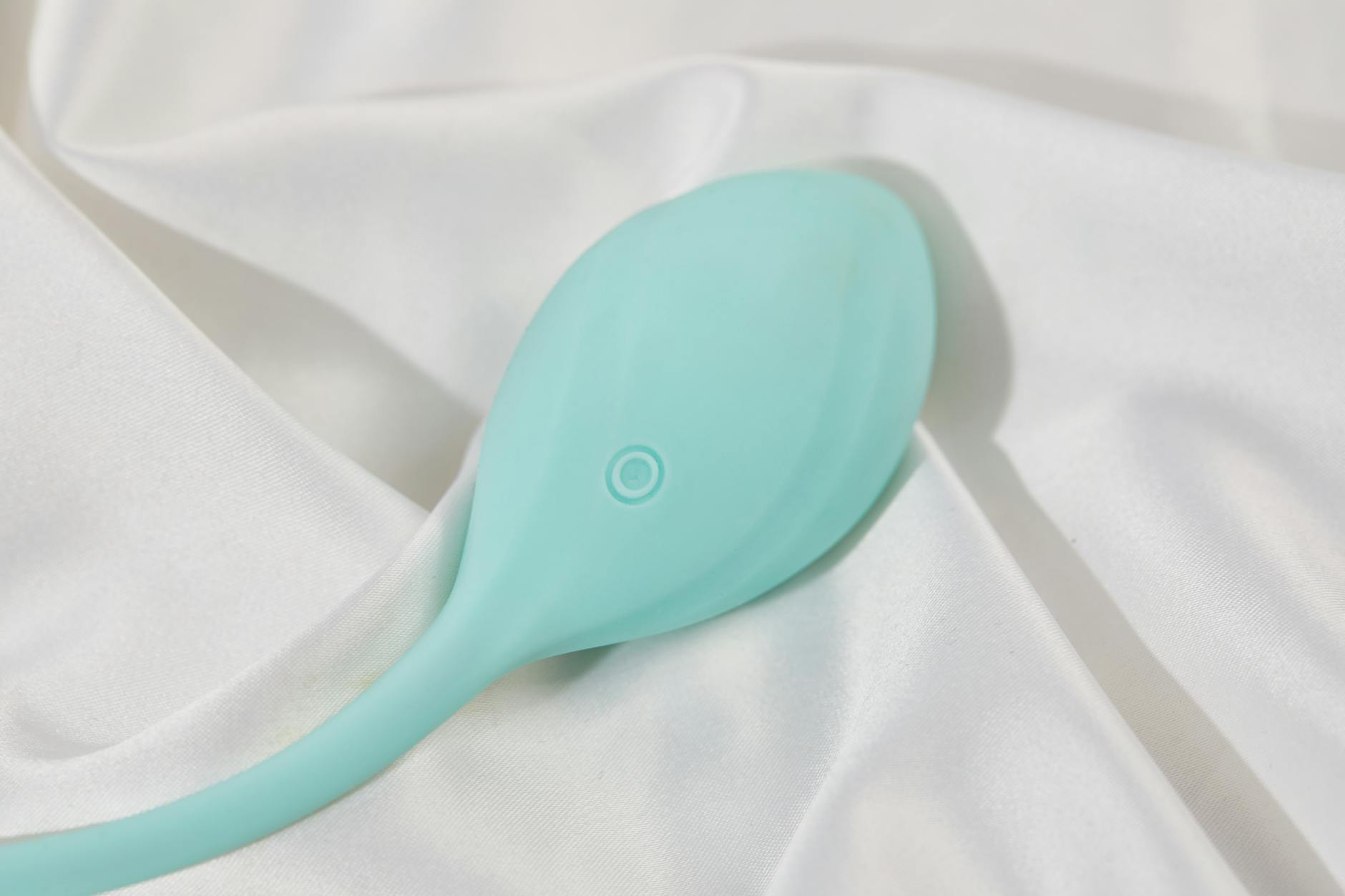 A blue silicone vibrator held gently in hand against a solid purple background, symbolizing self-discovery and pleasure