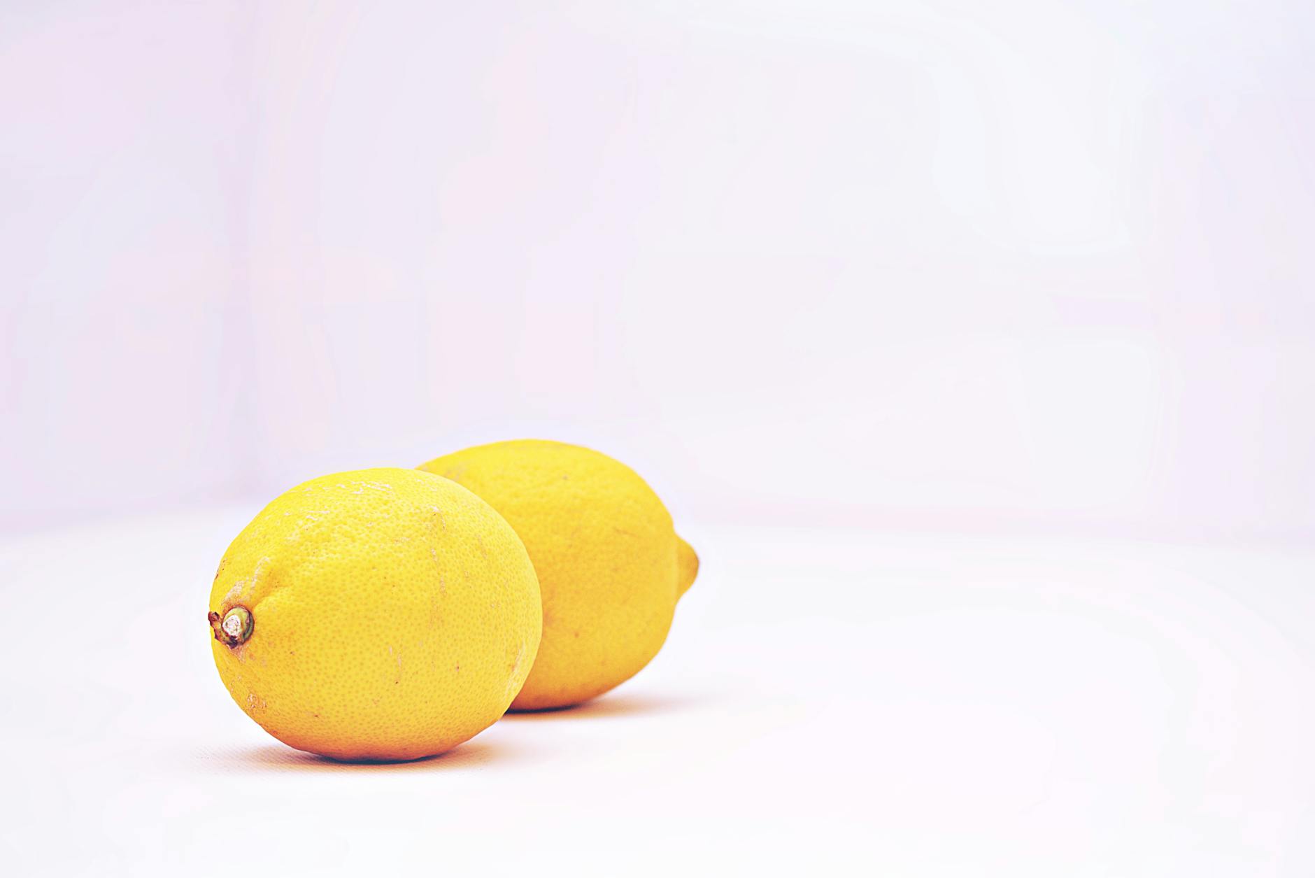 A lemon vibrator resting on a soft white surface, symbolizing gentle self-care and healing during difficult emotional times.