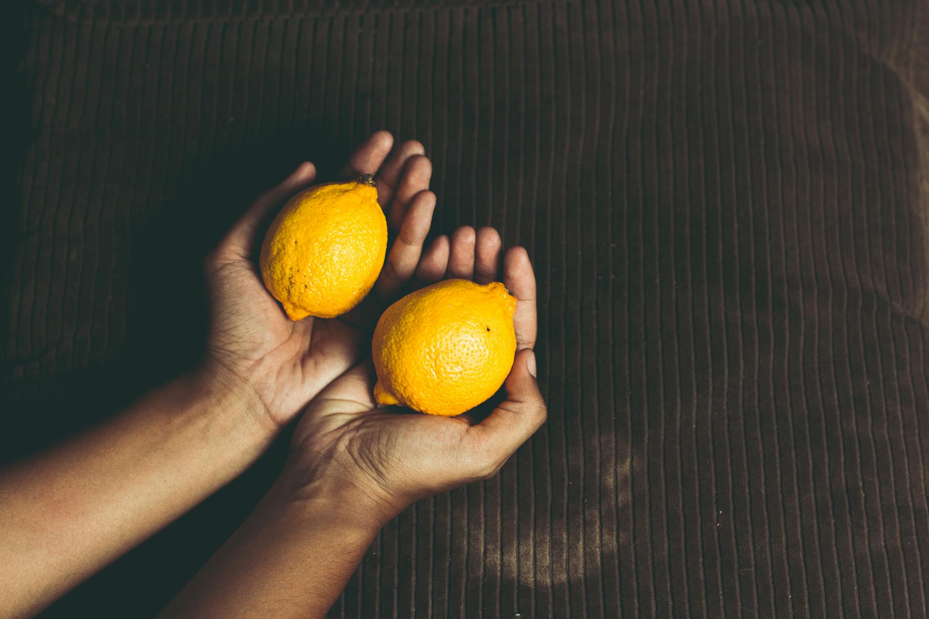 Deux citrons vibrants placés sur un fond blanc minimaliste, symbolisant la fraîcheur et la simplicité