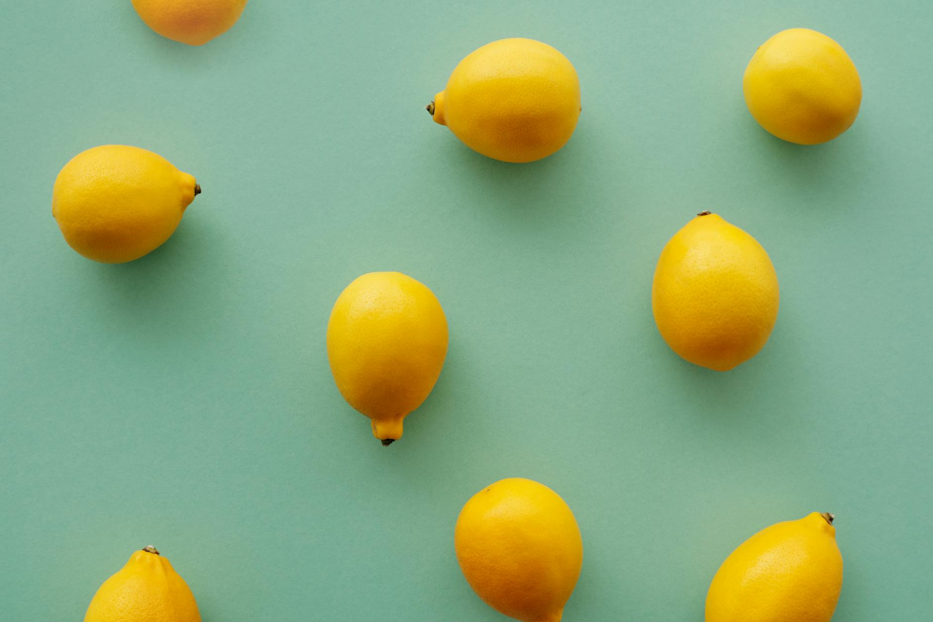 Bright yellow lemons arranged on a pastel green background, symbolizing fresh approaches to pelvic health