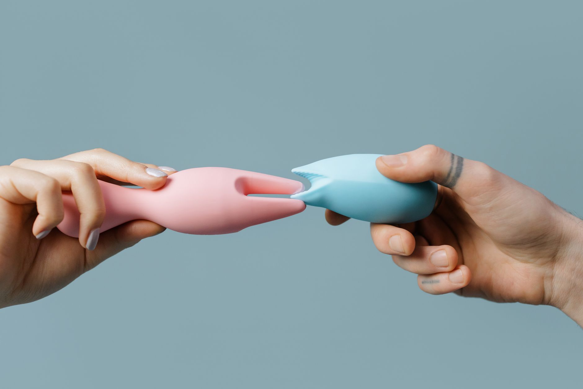 Hand holding a lemon vibrator against a purple backdrop, showing modern clitoral stimulation design