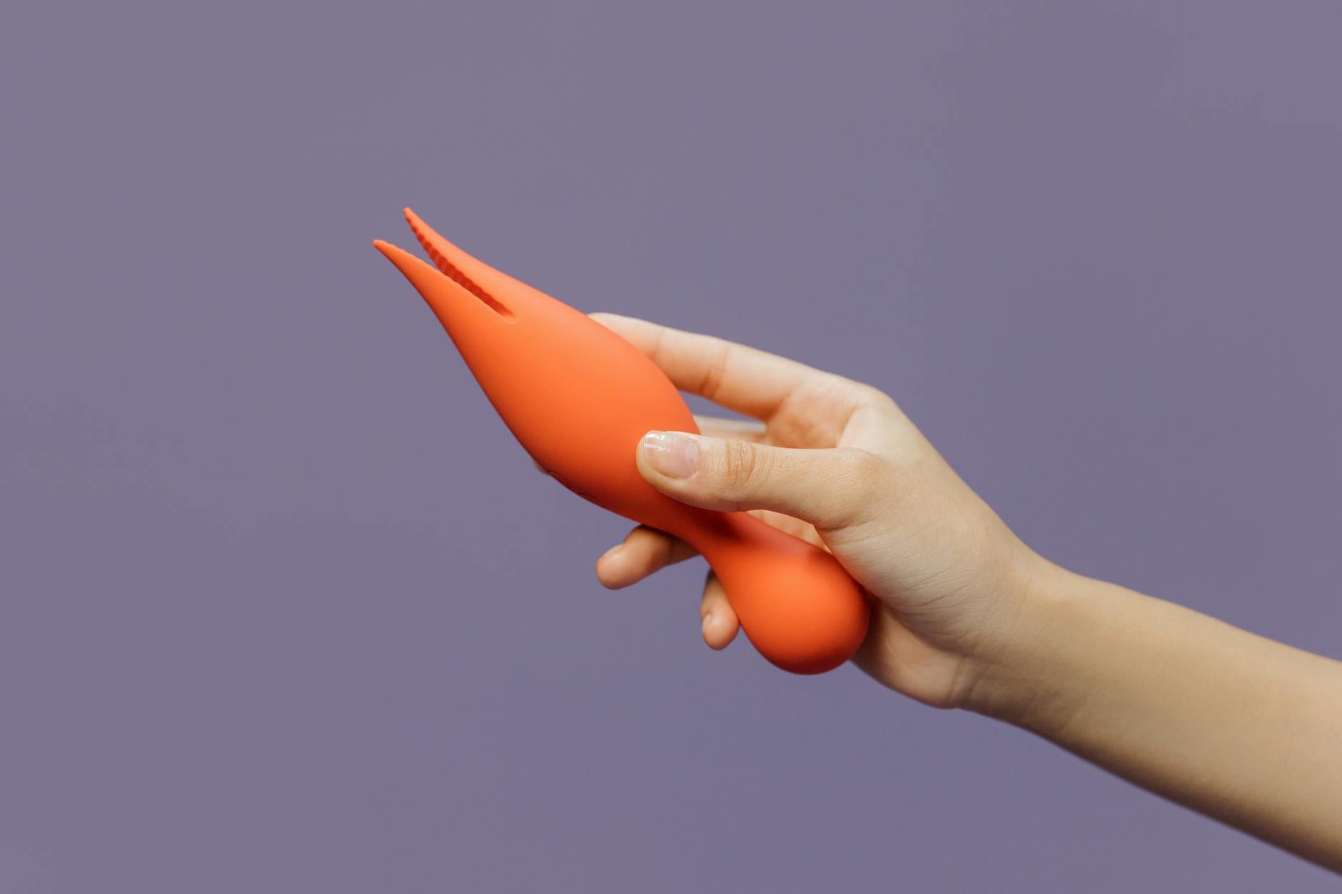A hand holding a vibrant lemon-colored vibrator against a minimalistic backdrop, symbolizing renewed pleasure