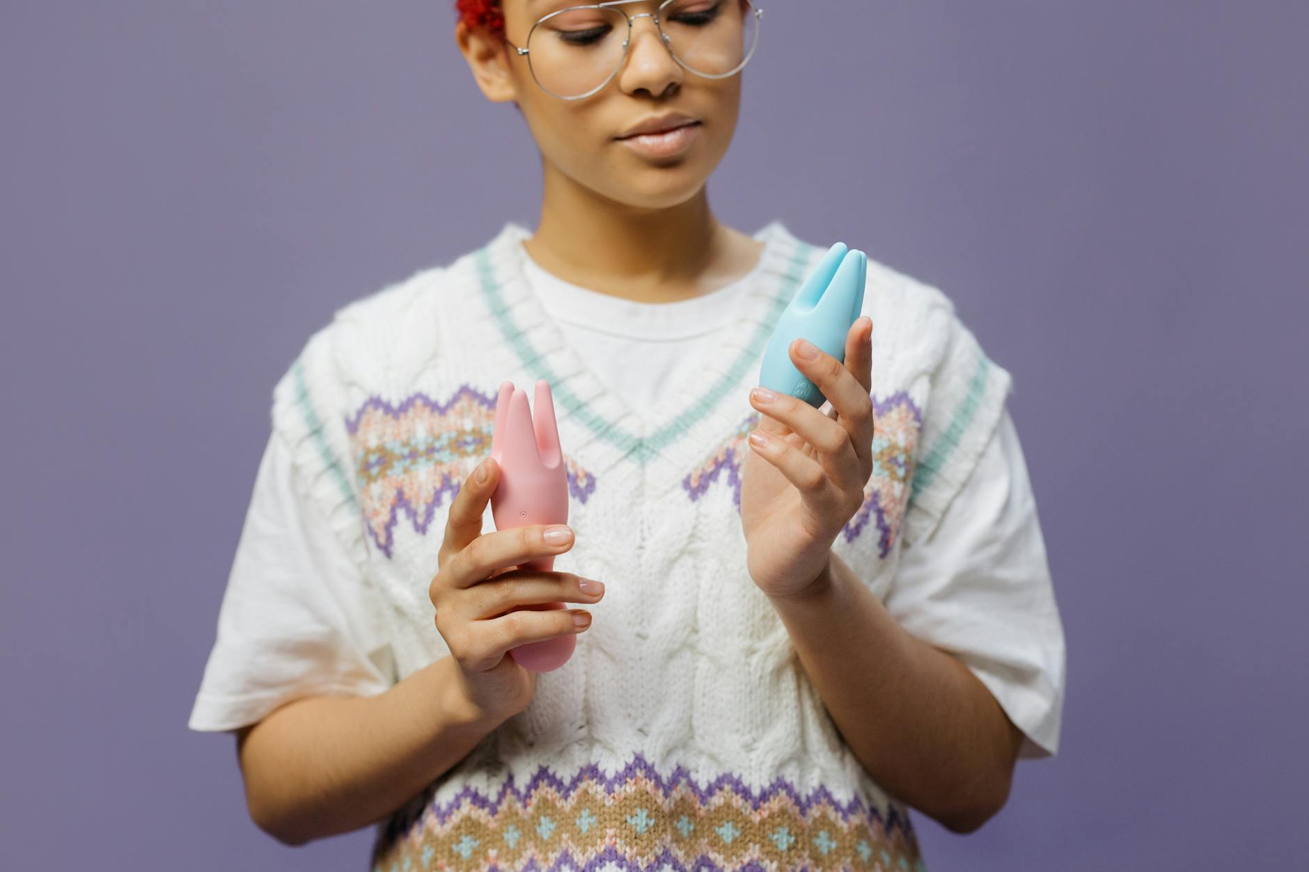 Woman holding and comparing different types of silicone vibrators