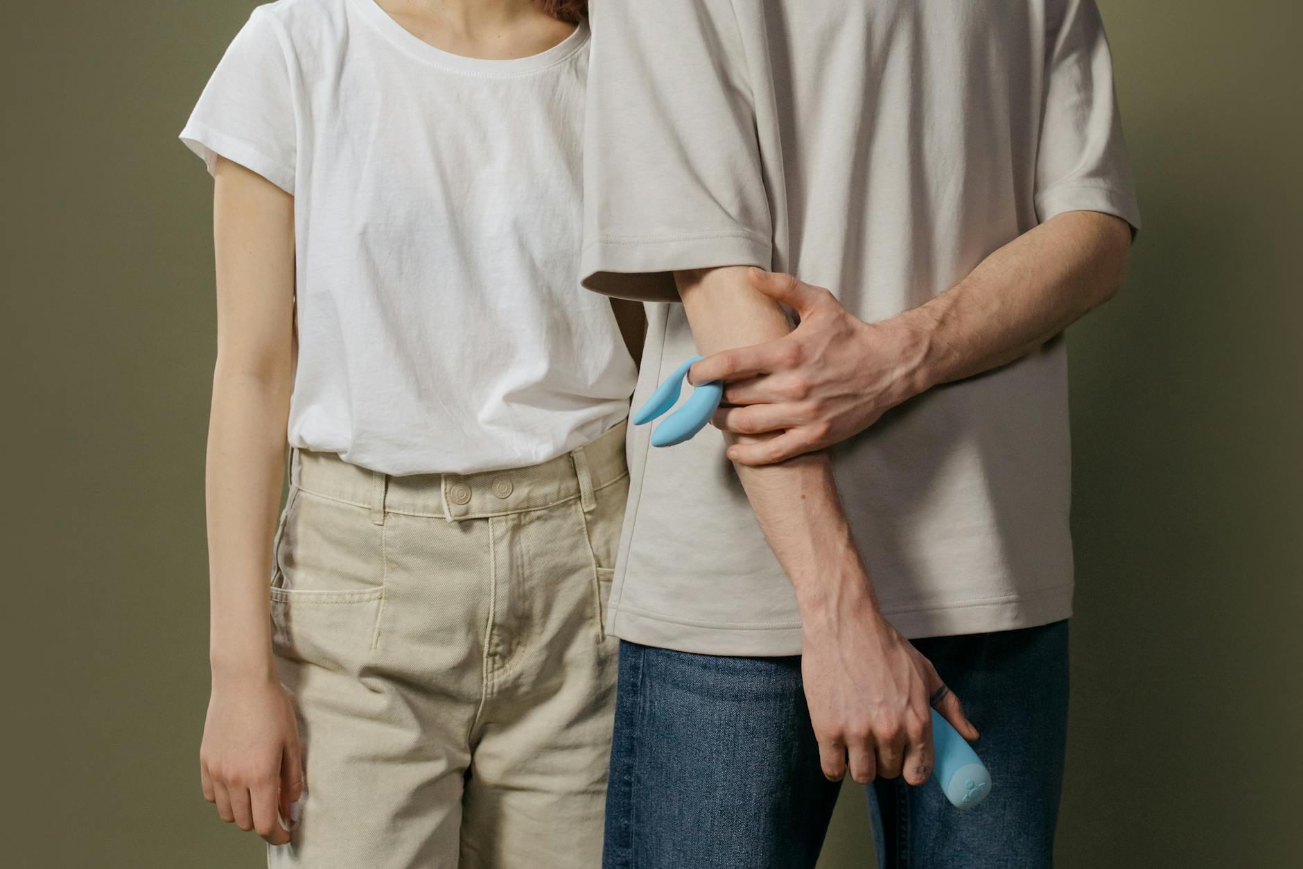 A couple holding a vibrator together, symbolizing shared vulnerability and reconnection after relationship distance